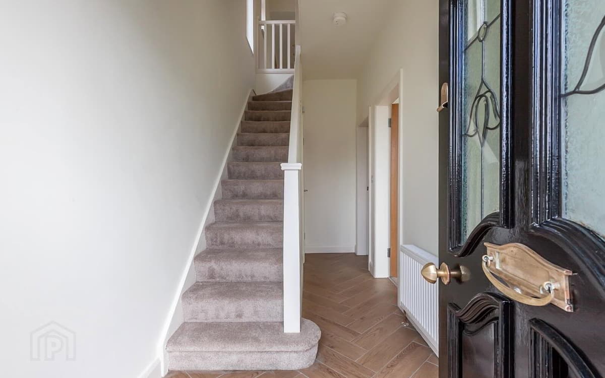 Renovated hallway and staircase in a Belfast home — new carpet, painted balustrade and herringbone-style floor